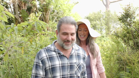 walking in lush green garden, mature couple having peaceful time outdoors