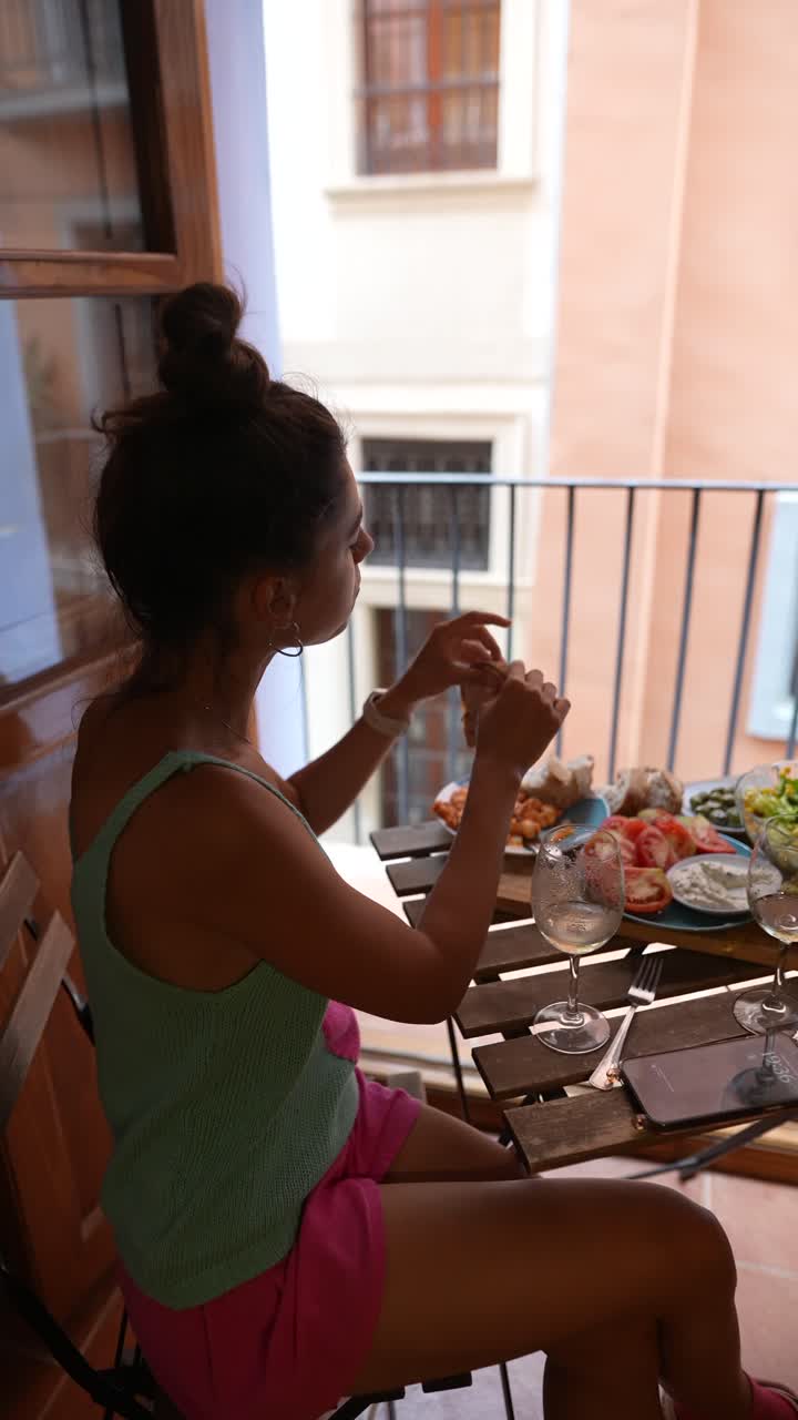 mujer comiendo almuerzo en un balcón