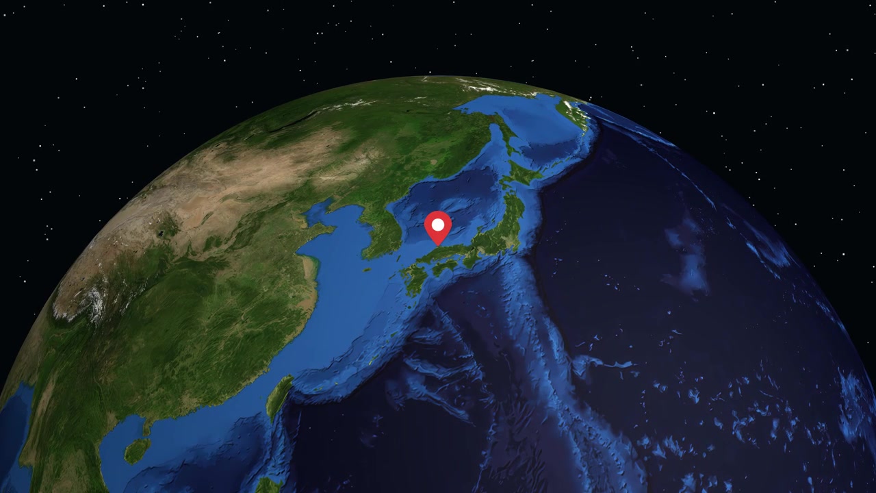 Digital globe rotates and zooms from space to a specific location marker in Japan
