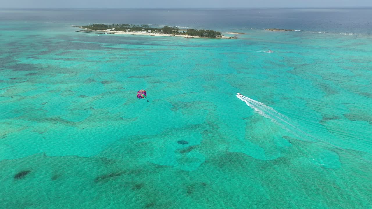 Parasailing in Tropical Water. Drone Aerial View of Colorful Parachute, Boat and Small Island, Bahamas