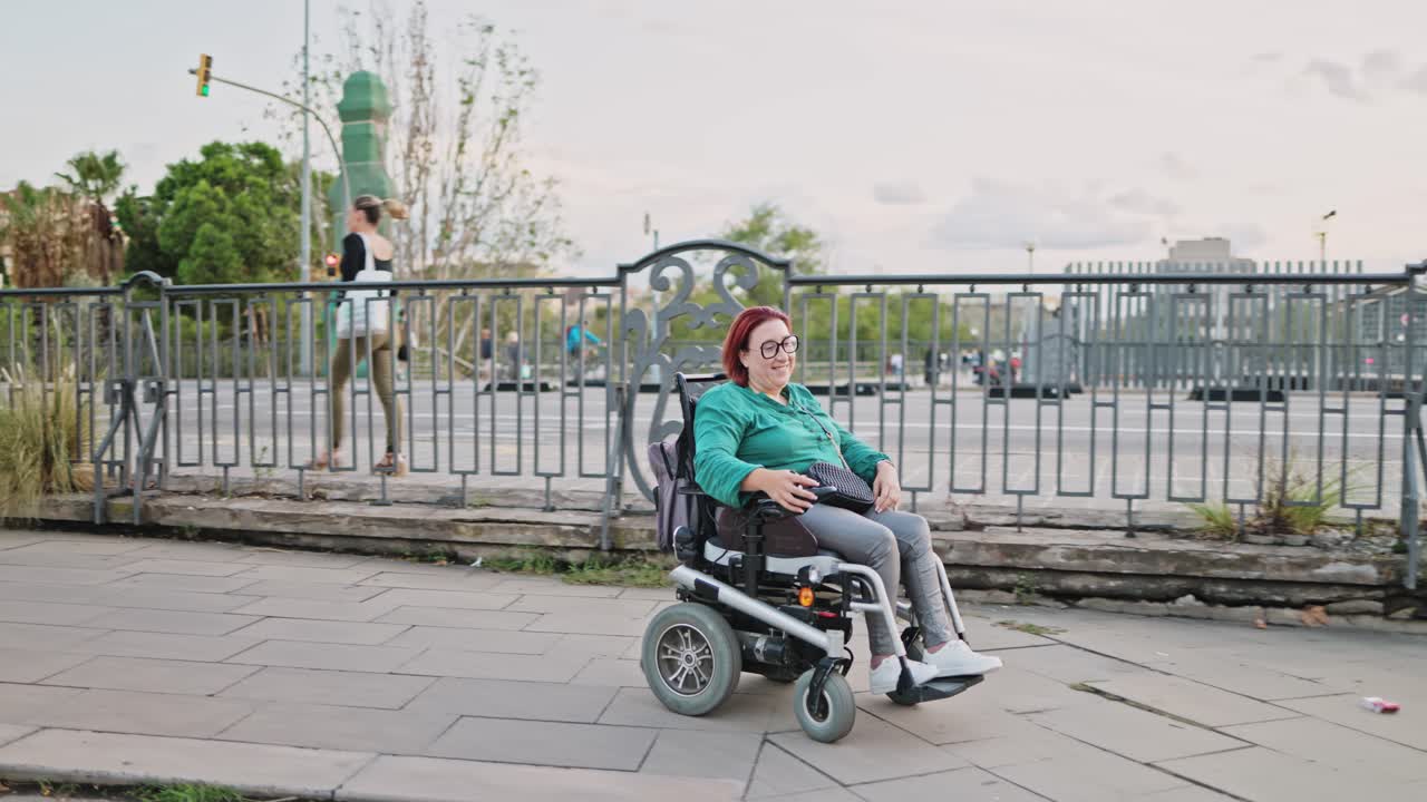 Happy Woman Driving Electric Wheelchair on City Sidewalk