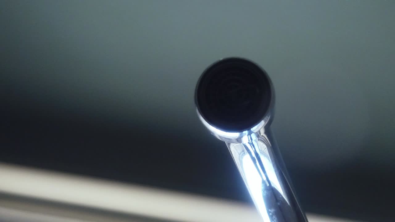 verter agua en un vaso de un grifo abierto