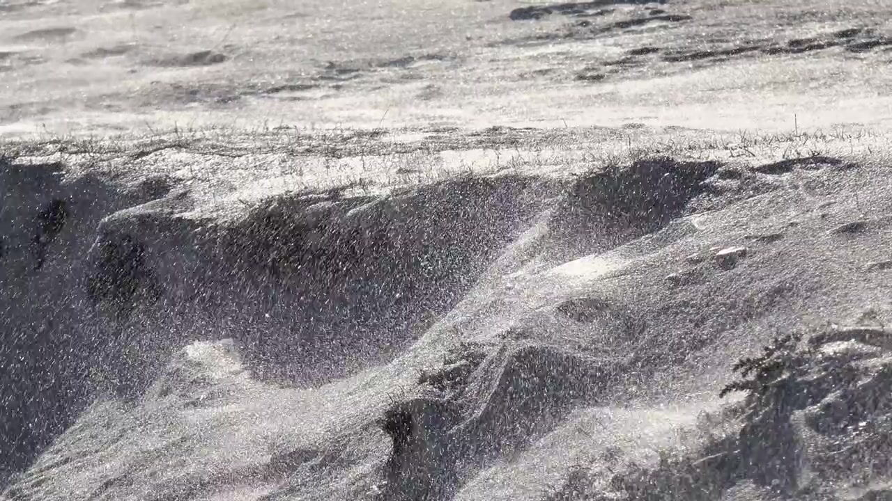 Vento forte che soffia neve su un paesaggio ghiacciato