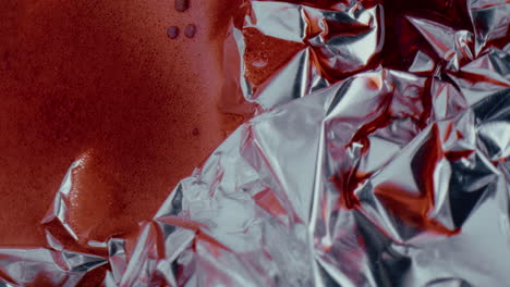 red liquid on crumpled foil
