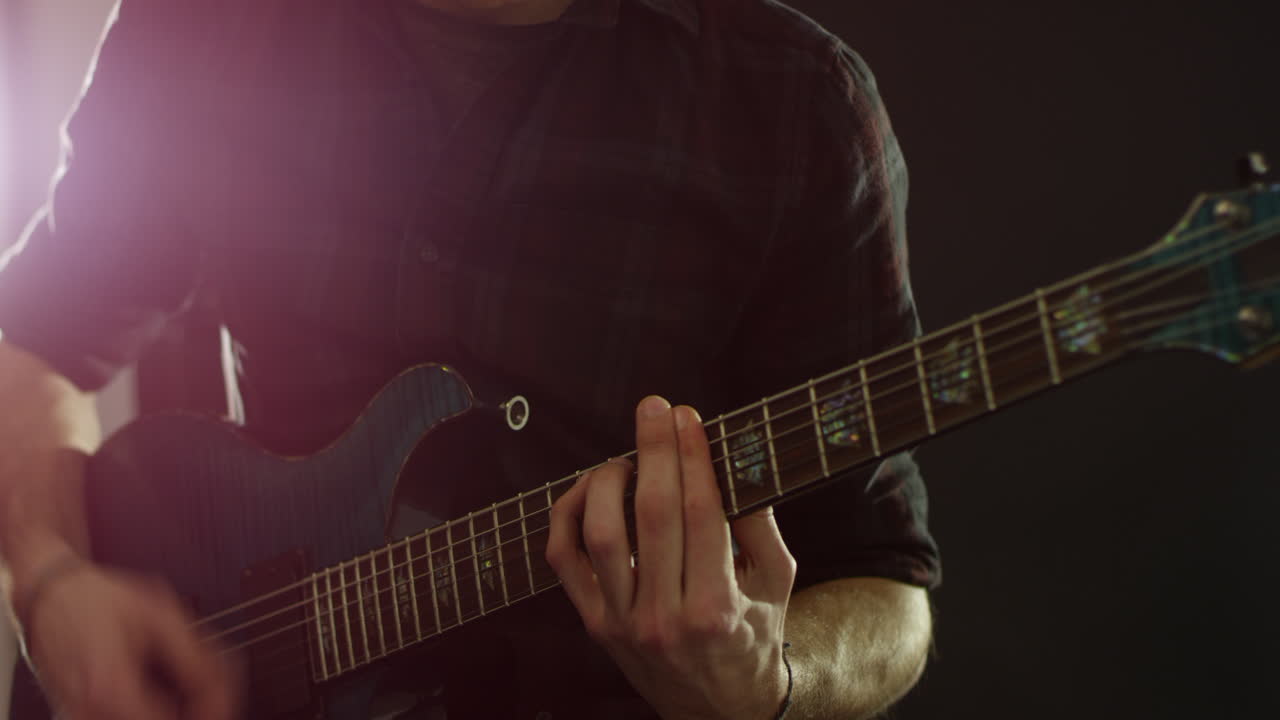 Gros plan sur un homme jouant de la guitare électrique, tourné en R3D