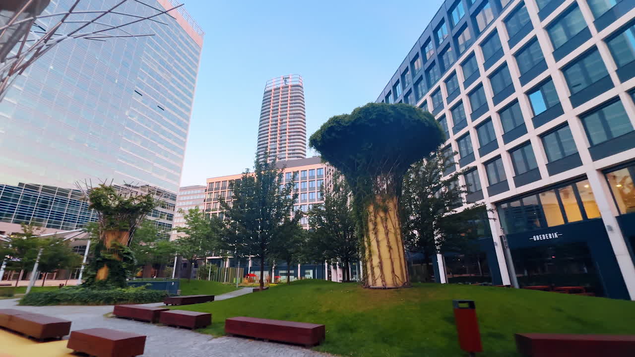 Bratislava, Slovakia - June 5, 2025: Urban greenery and modern design. A vibrant urban space showcasing contemporary buildings and unique trees, creating a balance of nature and design