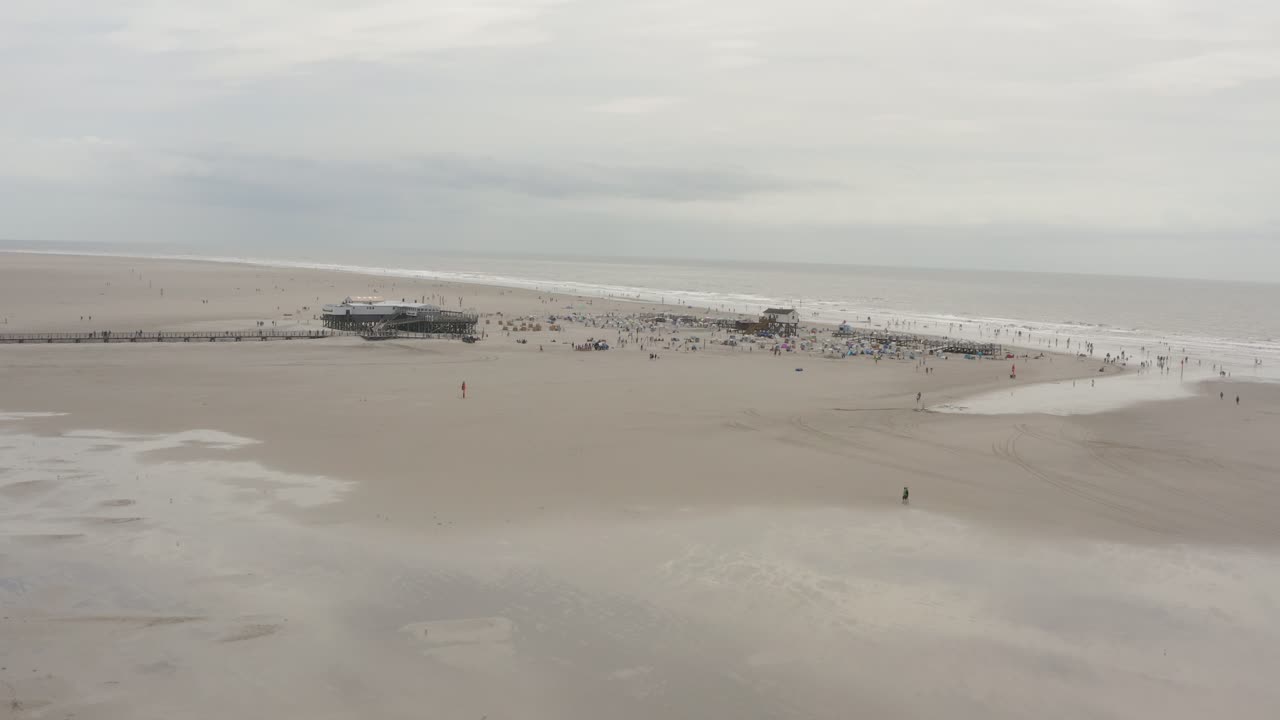 Drone - Aerial panorama shot of the sandy beach with tourists and people in St. Peter Ording at the north sea, schleswig holstein, germany, 25p