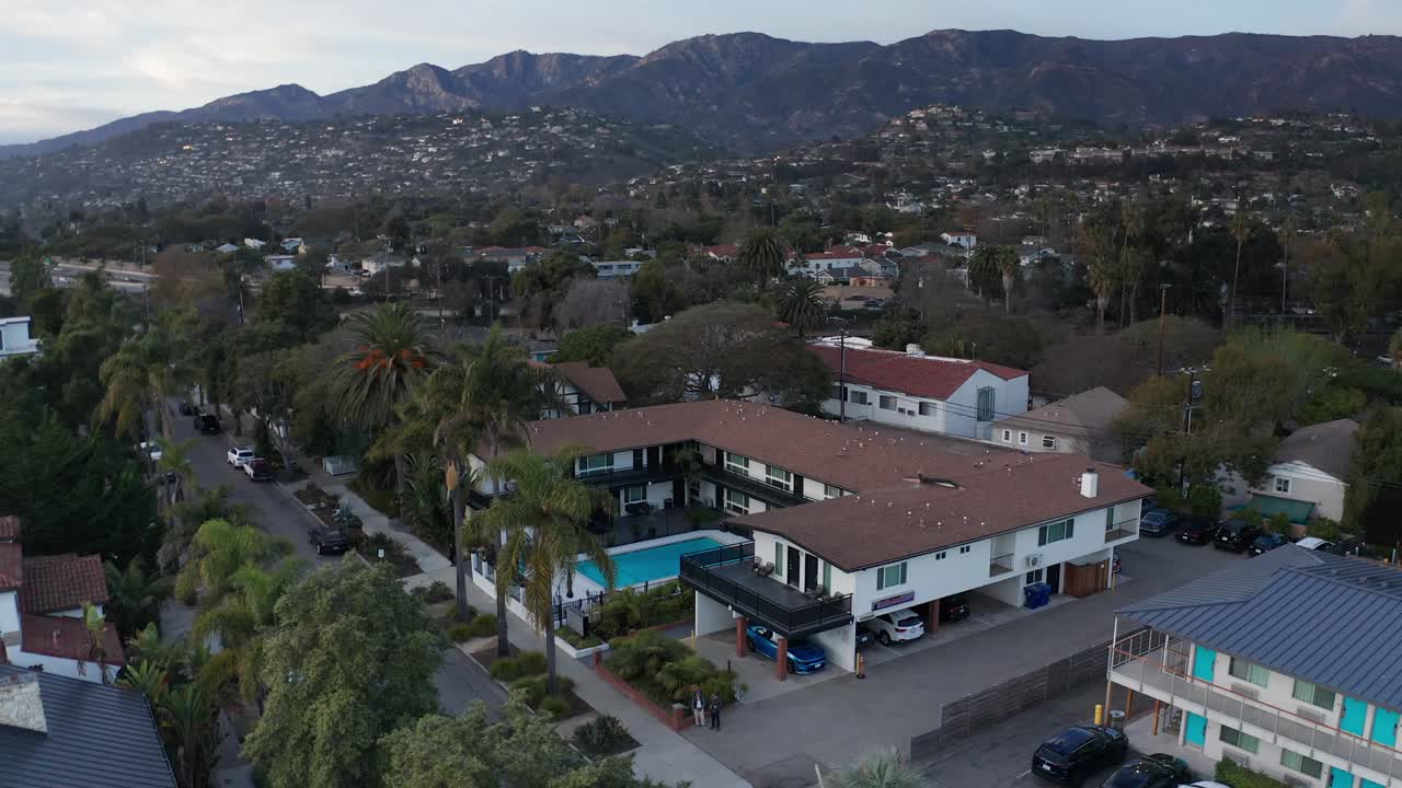 Toma aérea panorámica baja del encantador Seaside Inn al atardecer en Santa Bárbara, California. 4K