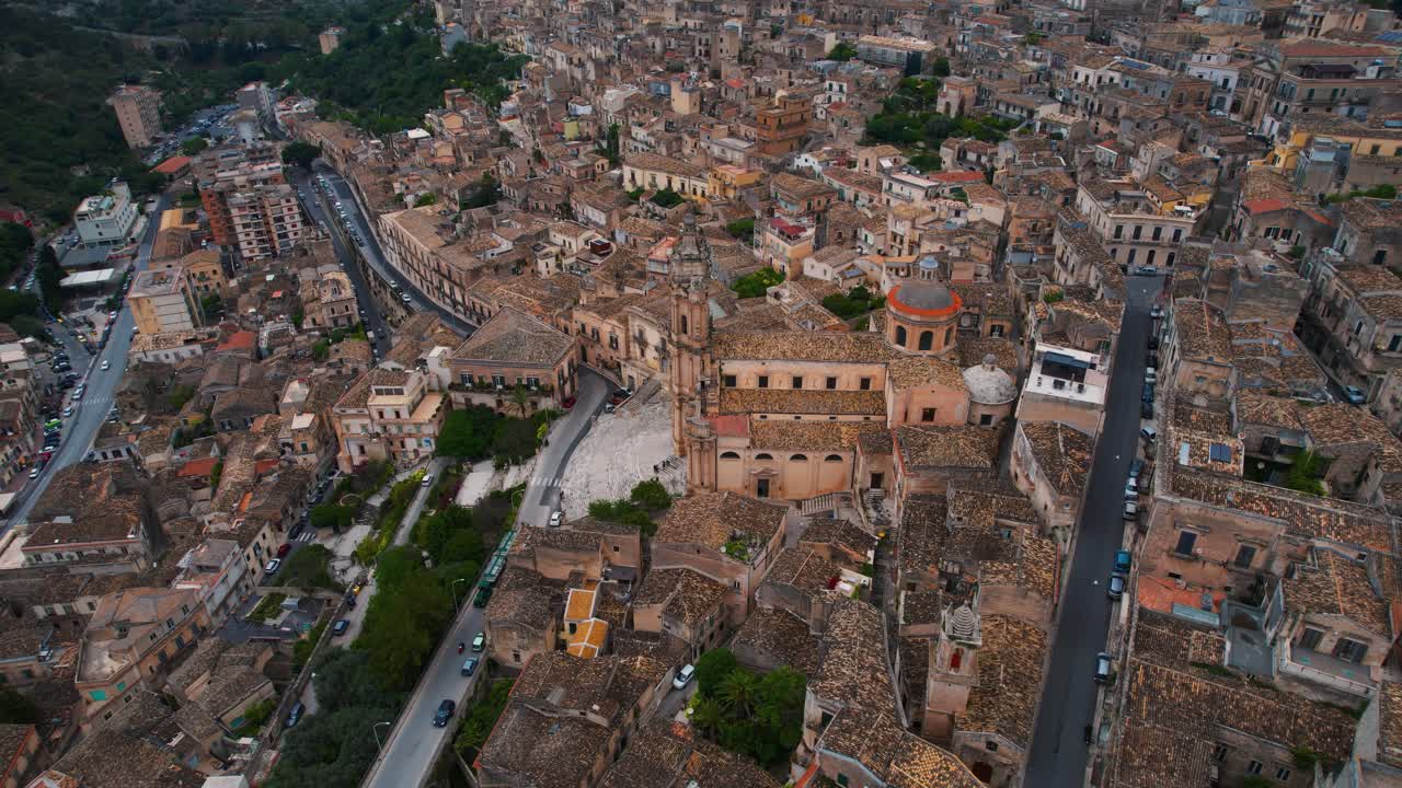 Drone rising at Modica old town. Elegant dome and stairs of Duomo di San Giorgio. Sicily, Italy.