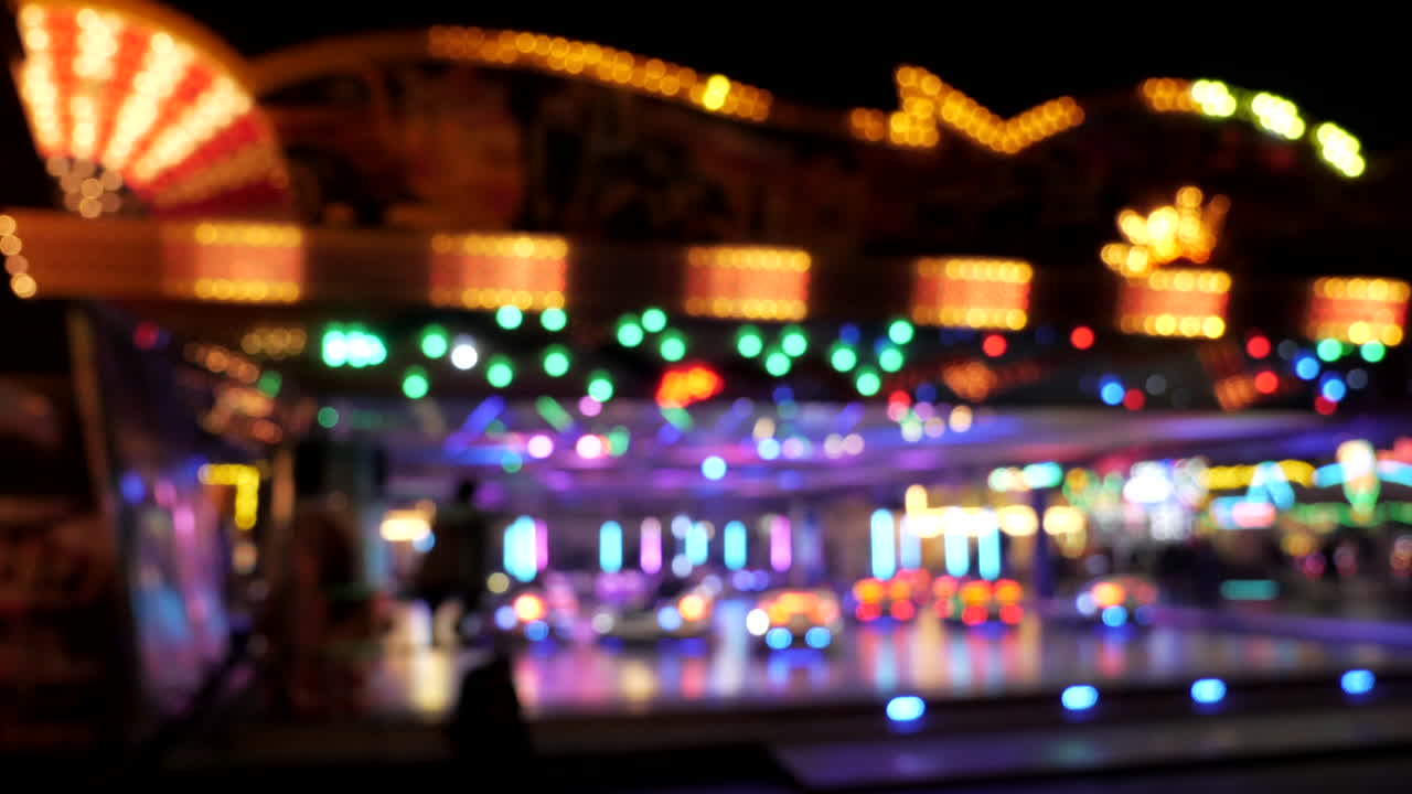 Bumper car carousel with blurred lights and people silhouette,wide shot