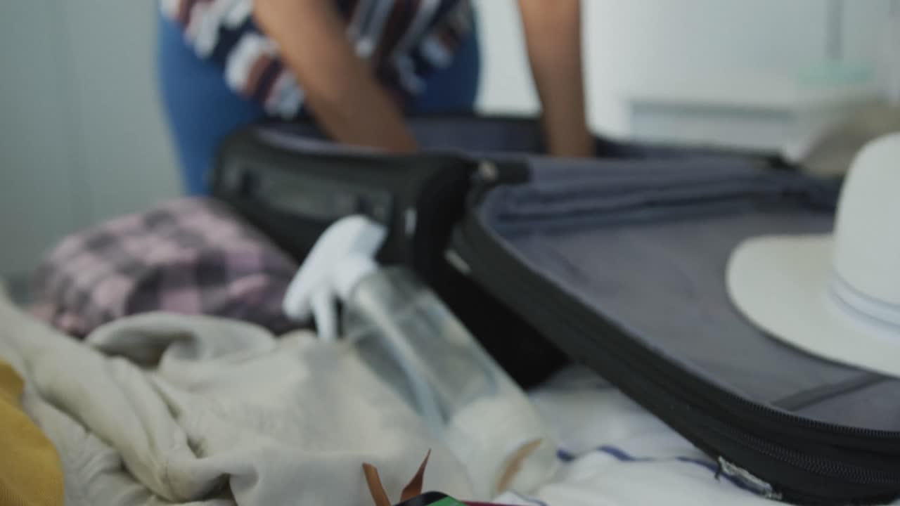 African american senior woman packing suitcase for travel