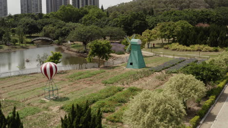 Molino-De-Viento-Decorativo-De-Estilo-Holandés-En-Un-Parque-Formal-Al-Lado-De-Un-Pequeño-Lago