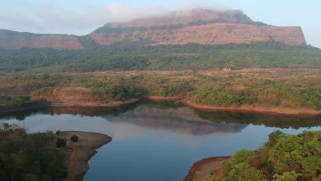 Start-Am-Frühen-Morgen,-Sobald-Die-Ersten-Sonnenstrahlen-Auf-Die-Ausläufer-Der-Sahyadri-Kette-In-Der-Nähe-Von-Lonavala,-Indien,-Treffen---Drohnenaufnahmen-Aus-Der-Luft-Mit-See