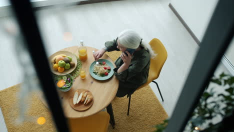 woman eating lunch and talking on phone