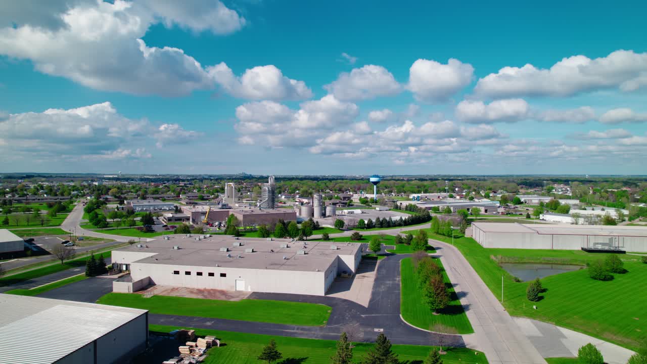 Industrial district in De Pere, Wisconsin, with clean roads, warehouse facilities, and a bright, cloud-filled sky.