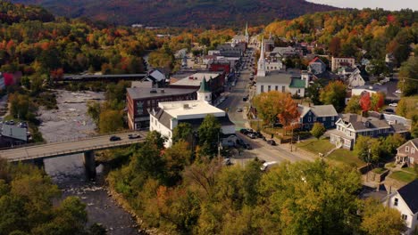 Flyover-of-new-England-town-with-churches-and-covered-bridge-during-autumn-fall-foliage-season