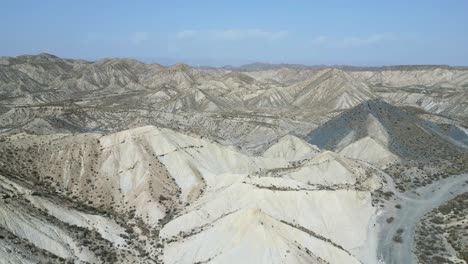 Drone-view-of-rough-rocky-mountains-with-dry-river-in-daylight