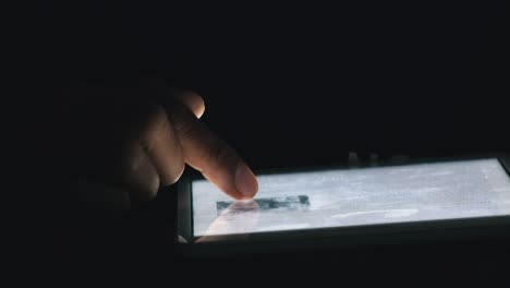 close shot of somebody using a tablet at night