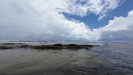 Beautiful-landscape-shot-of-the-calm-Tibau-do-Sul-beach-with-large-rocks-blocking-the-waves-near-Pipa,-Brazil-in-Rio-Grande-do-Norte-during-a-cloudy-summer-day