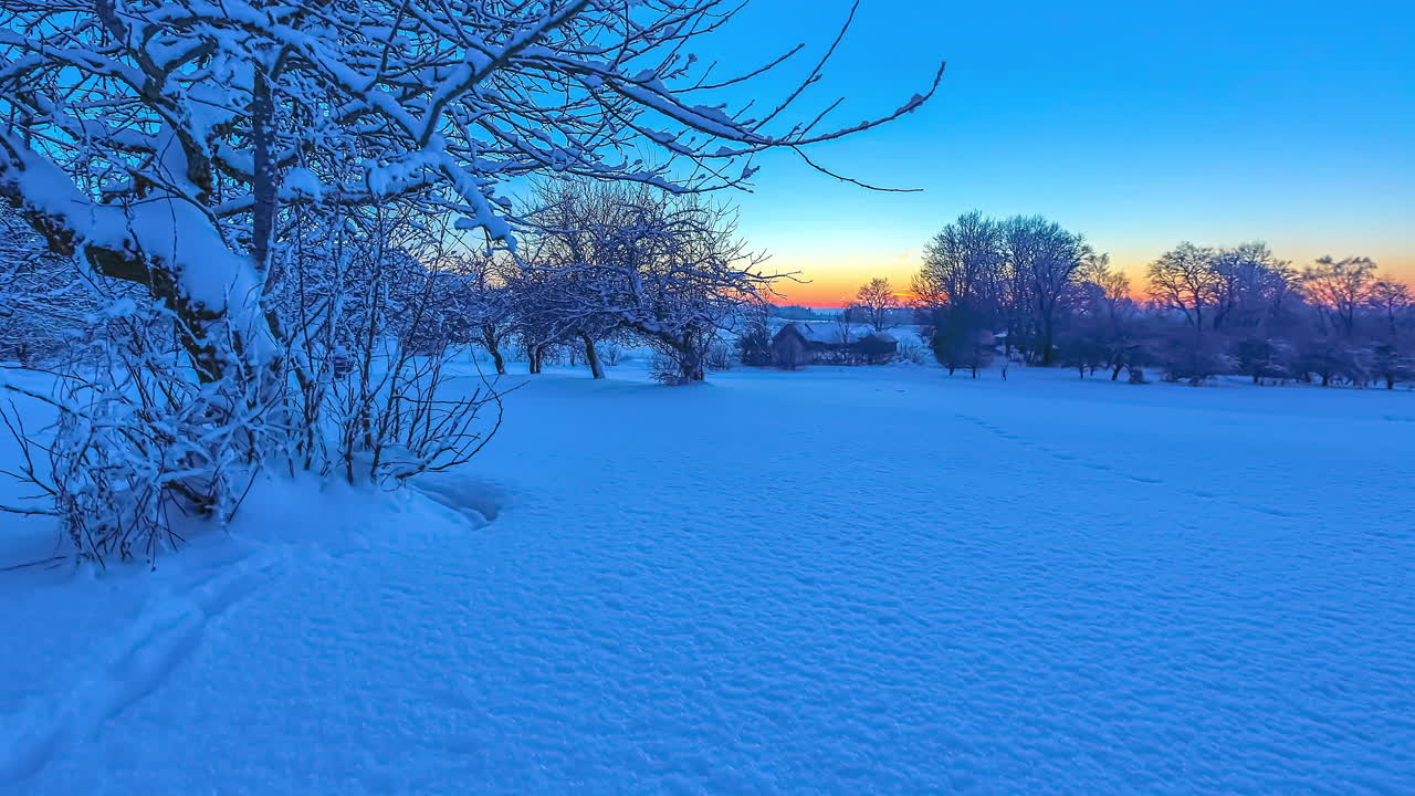 Hyper lapse shot of beautiful winter landscape with white snow during golden sunset at horizon