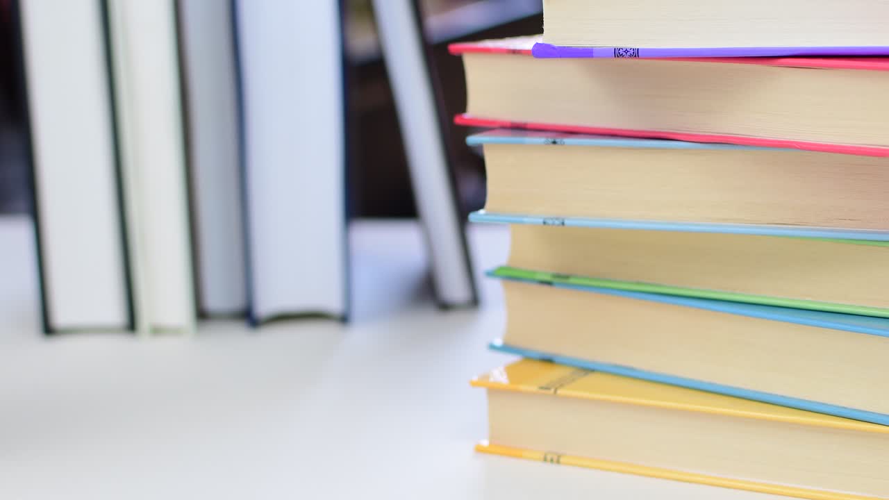 Desk with stack of study books. Textbooks for the student, university. Study from home. Distance education concept.
