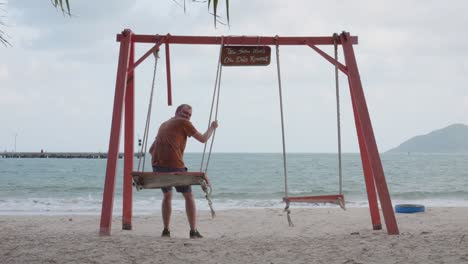 man swinging at the beach, bãi tắm an hải in vietnam - wide