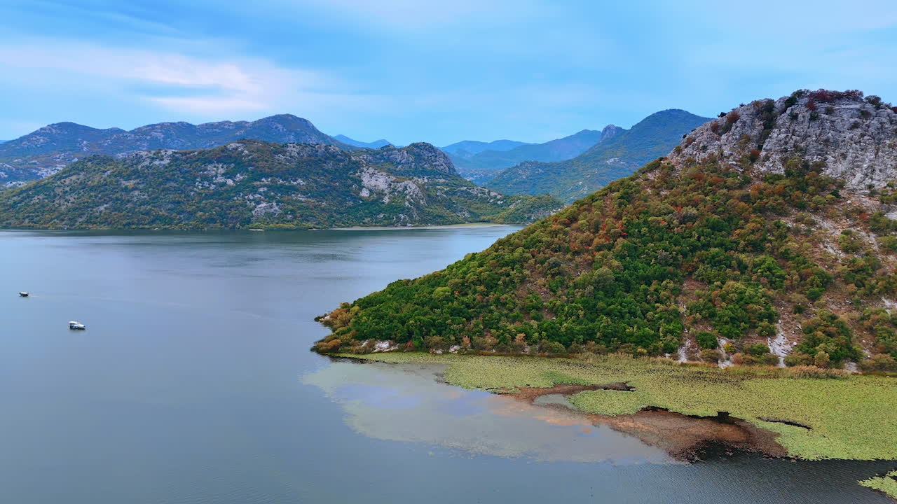 Waterscape covered with the weeds. Some boats stand on the water among the rocky islands. Aerial perspective