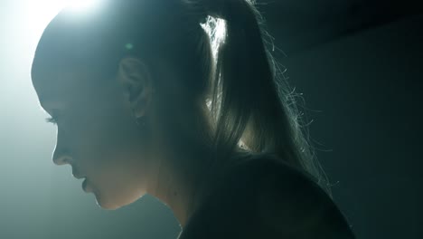 back view closeup of a woman cycling, camera moving upward from her glutes to her hair as she flips it from left to right. the shot transitions through profile to a frontal view of her focused face