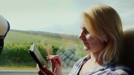 Side-View-Of-A-Young-Woman-Traveling-By-Bus-And-Using-A-Tablet