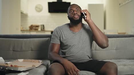 upset man watching sport game on tv at home kitchen. sad guy speaking with tv