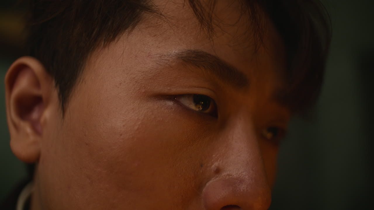 Close-up shot of a man's focused, intense expression with slight detail on skin texture