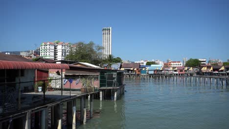 panning penang heritage clan house at sea with background komtar