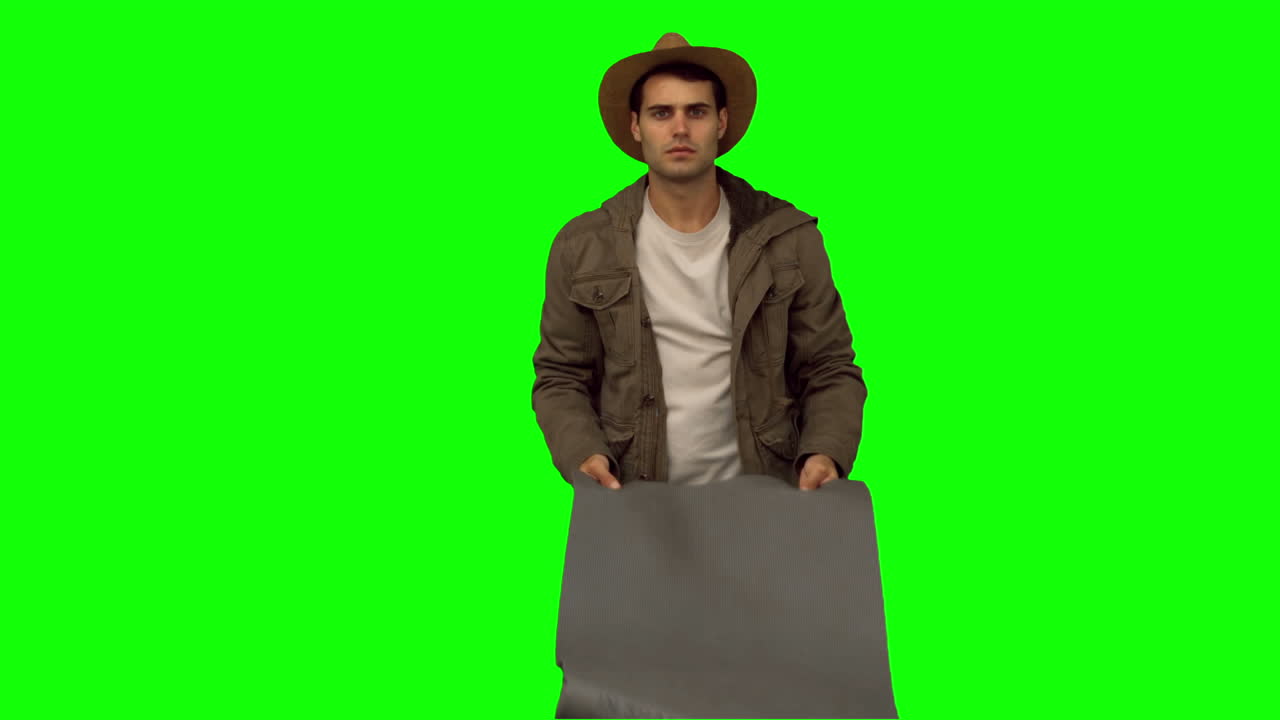 hombre desplegando una bolsa de dormir en la pantalla verde