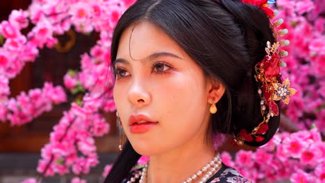 closeup shot of qing dynasty woman with pink blossoms in background