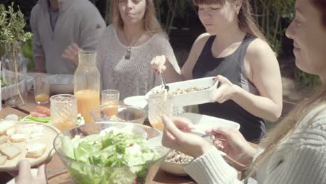 smiling friends eating healthy food outdoor