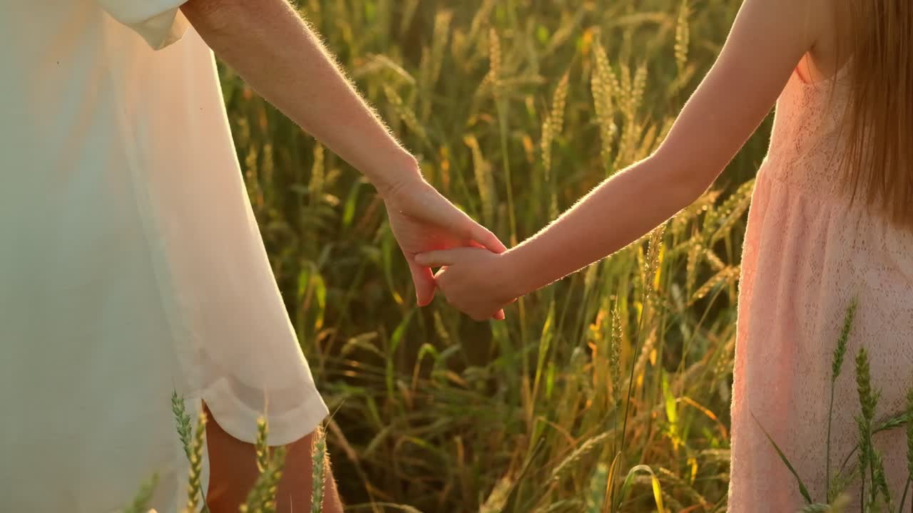 Mother and Daughter Holding Hands in a Wheat Field