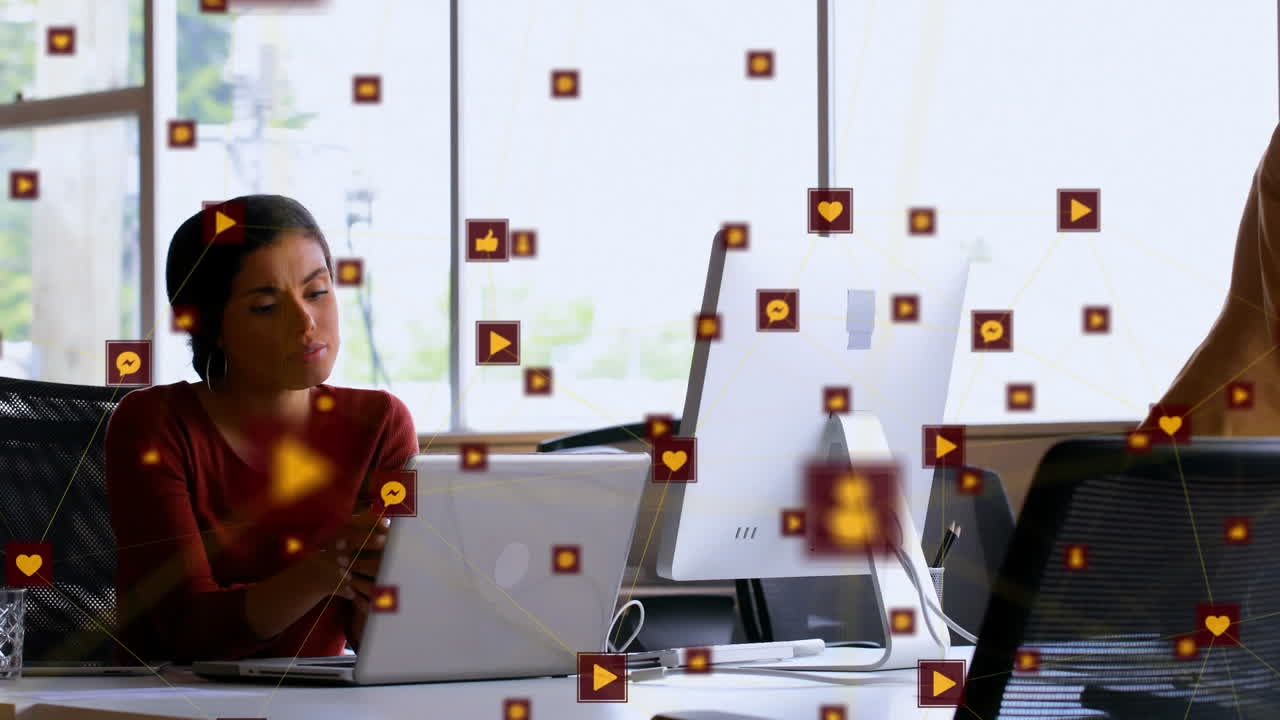 Animation of network of digital icons over biracial woman using laptop at office