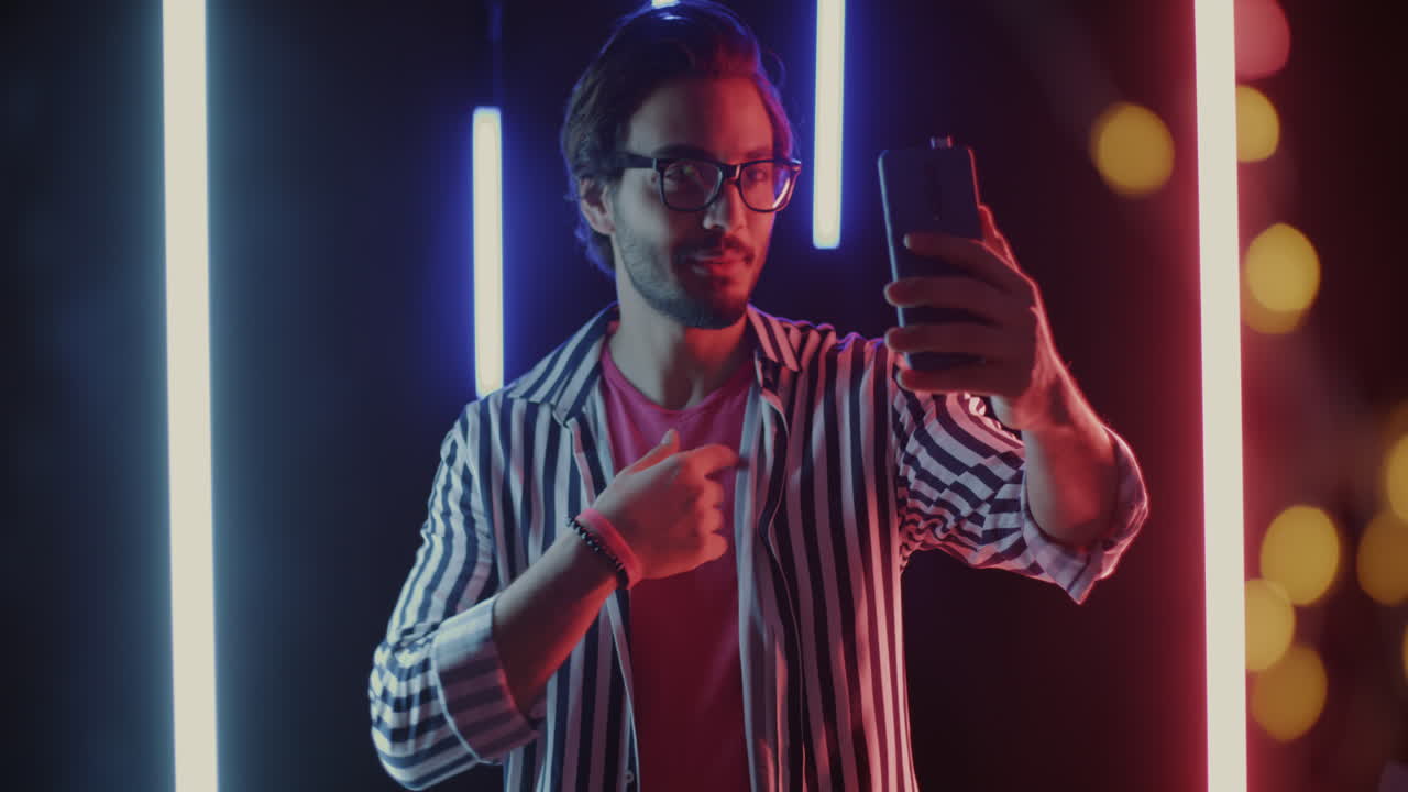 Man Making a Video Call with Neon Lights