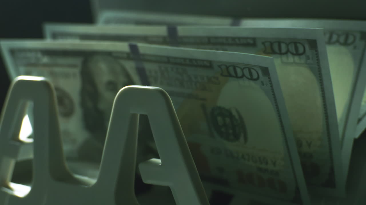 billetes de 100 dólares en una máquina contadora