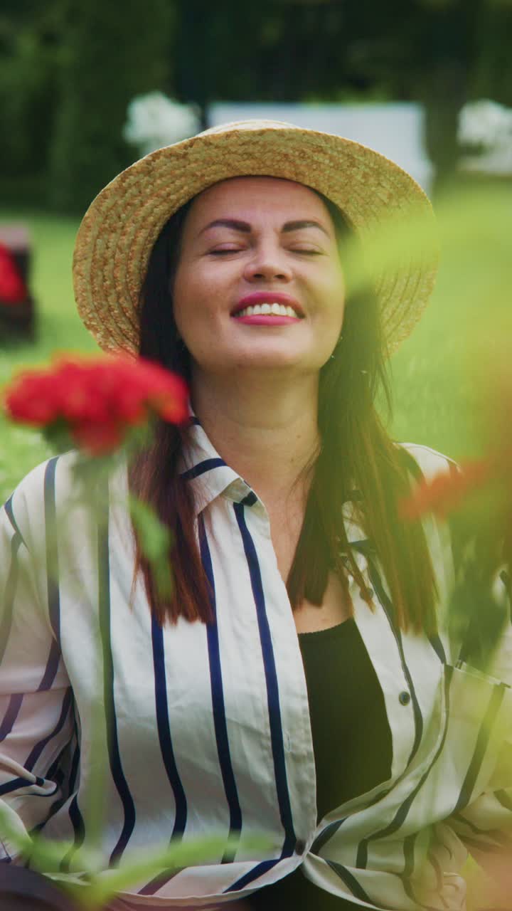Un momento di serenità nella natura: una donna con un cappello di paglia si gode la bellezza dei fiori, immersa nella tranquillità e nella beatitudine di un lussureggiante ambiente verde