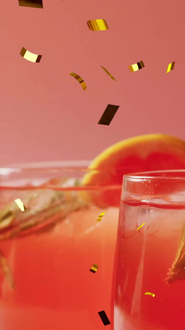 Animazione di coriandoli che cadono e un cocktail su sfondo rosa
