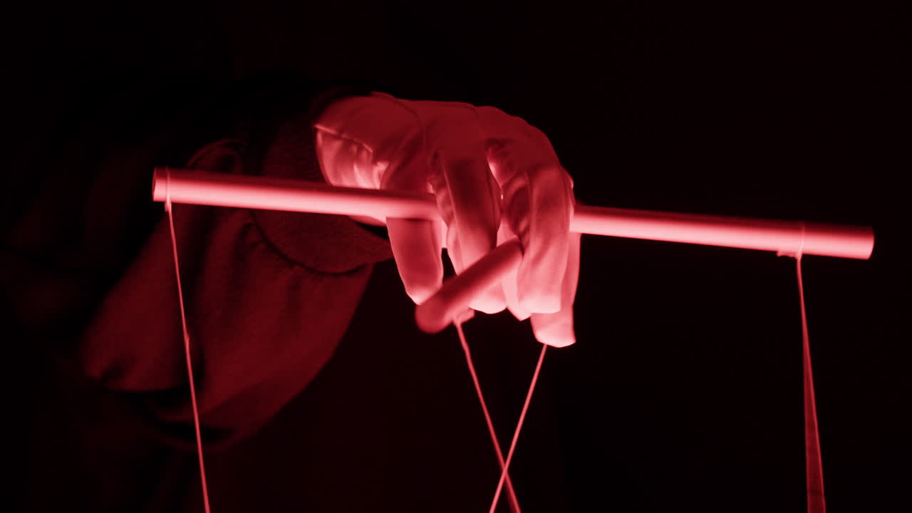 Close-up of Gloved Hand Manipulating Puppet Control Bar