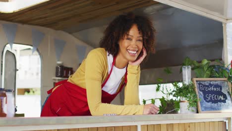 portrait of african american woman wearing apron smiling while standing in the food truck