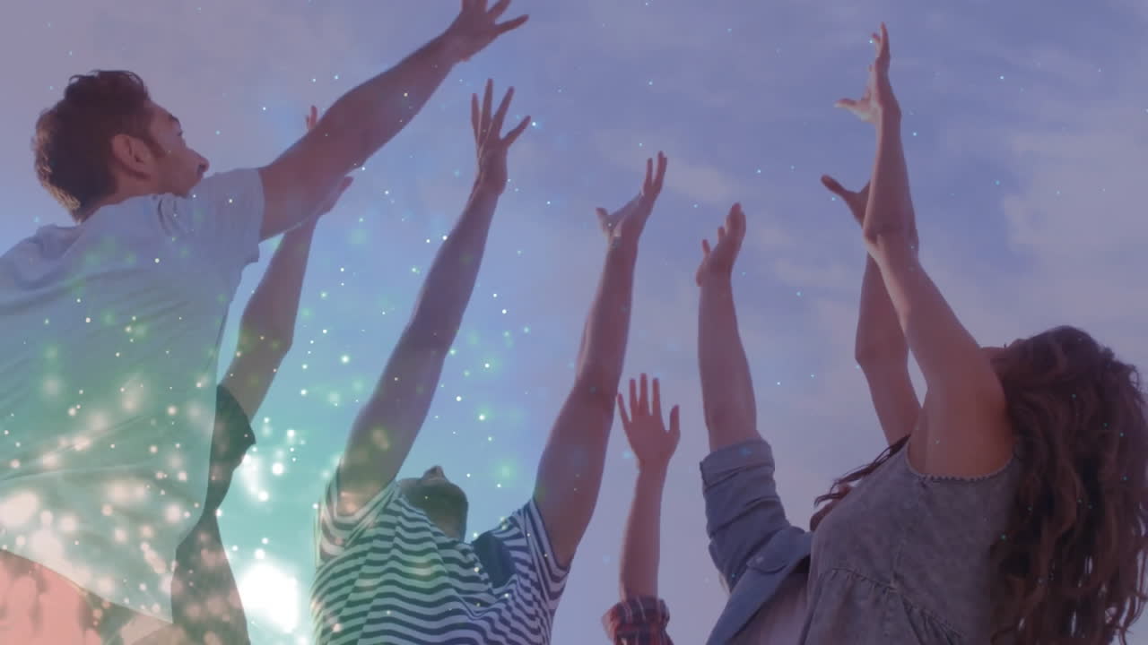 Group of people joyfully raising hands with sparkling light animation over them