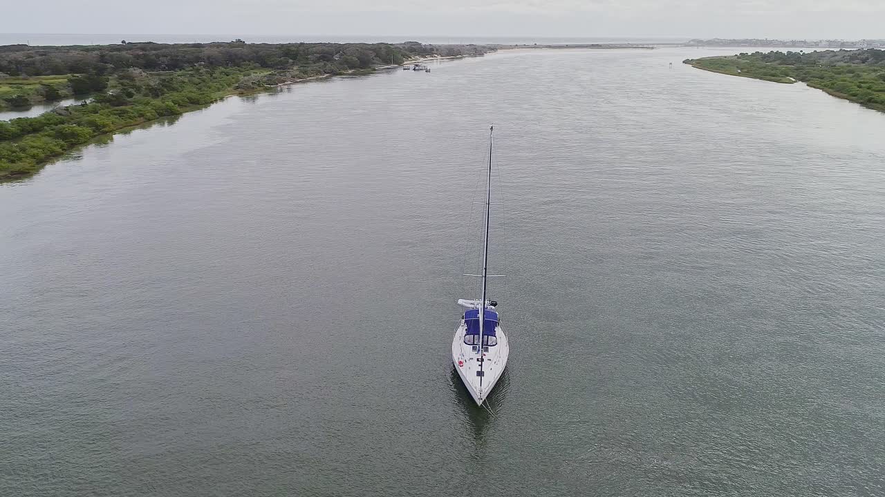 tiro medio orbital de un yate blanco estacionado en un río por la tarde