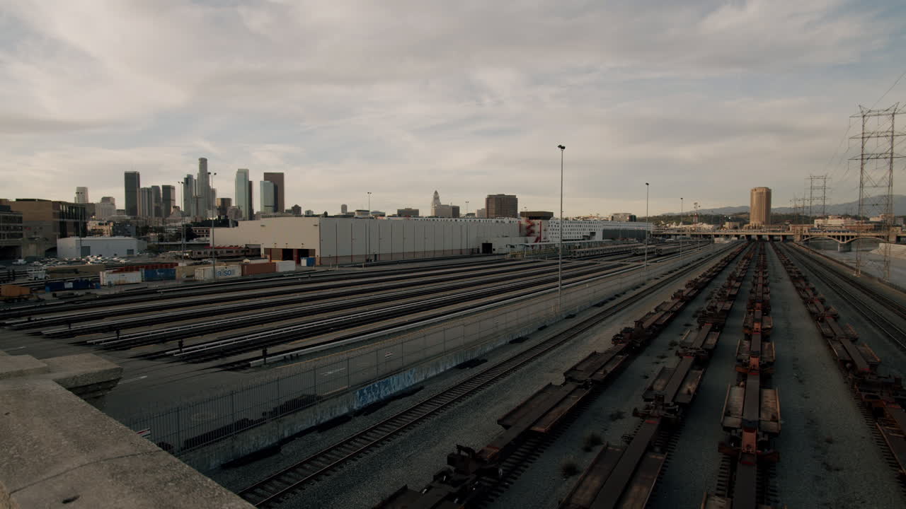 Panoramic view of a large railway yard with city skyline in the background