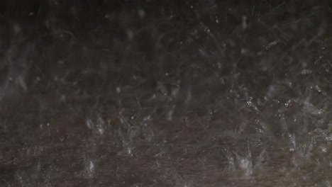 water hitting a concrete sidewalk during a heavy rain storm