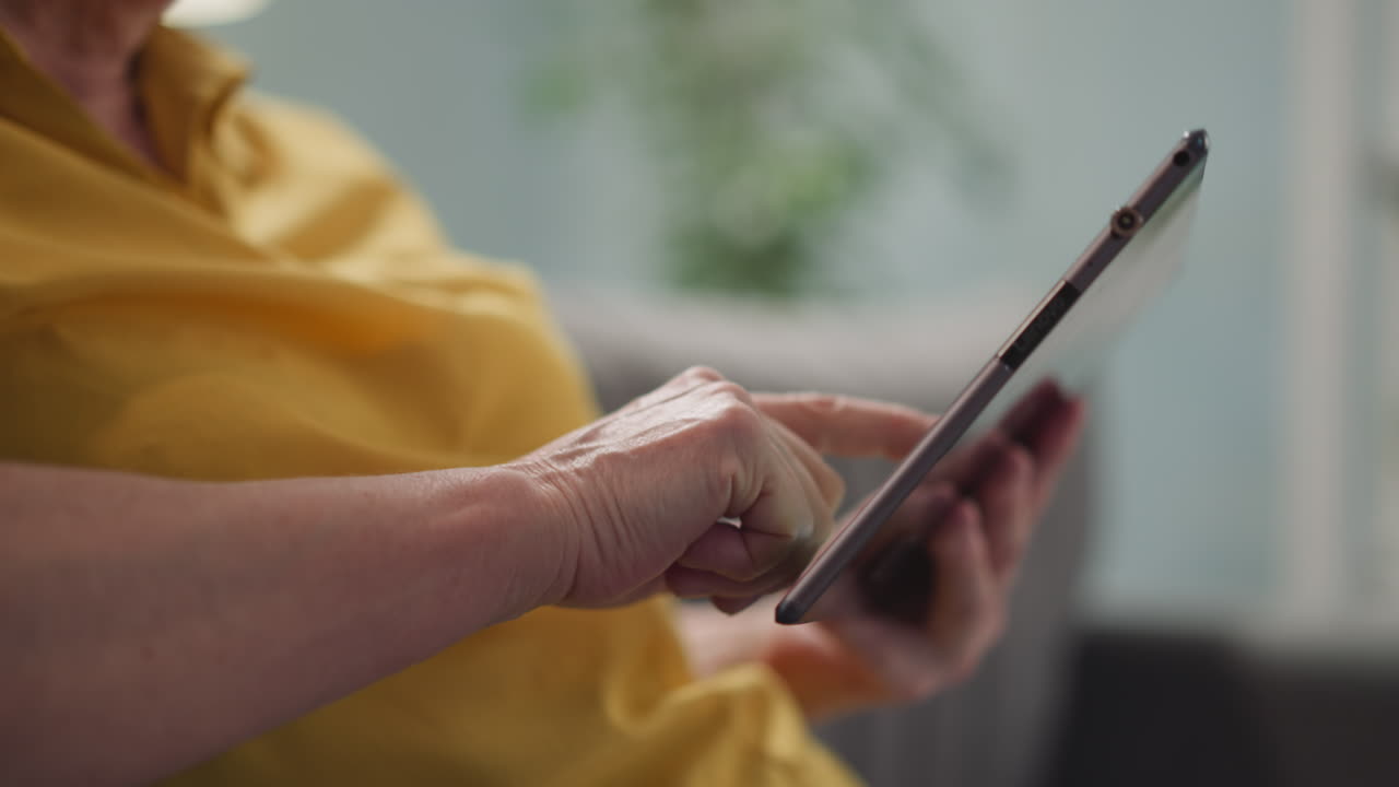 mujer mayor se comunica en chat en línea a través de una tableta en casa