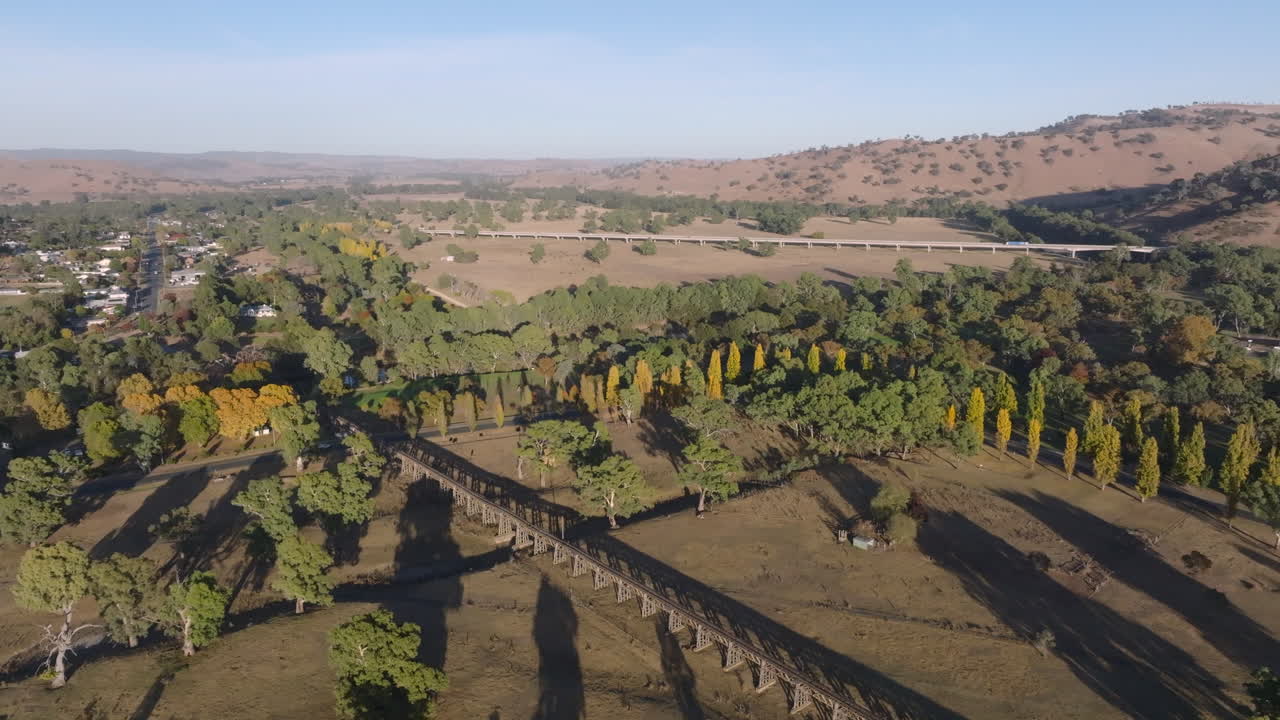 Aerial: Drone shot of Gundagai's historic old railway bridge in Gundagai town, NSW Australia