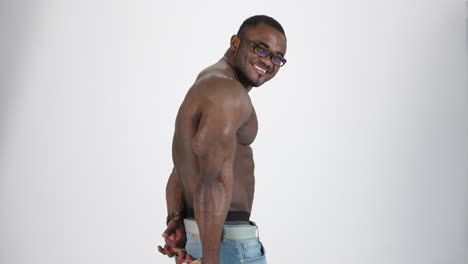 muscular afro american guy in studio. shirtless sportsman with black skin posing on camera on white background. smiling athlete with sportive body.